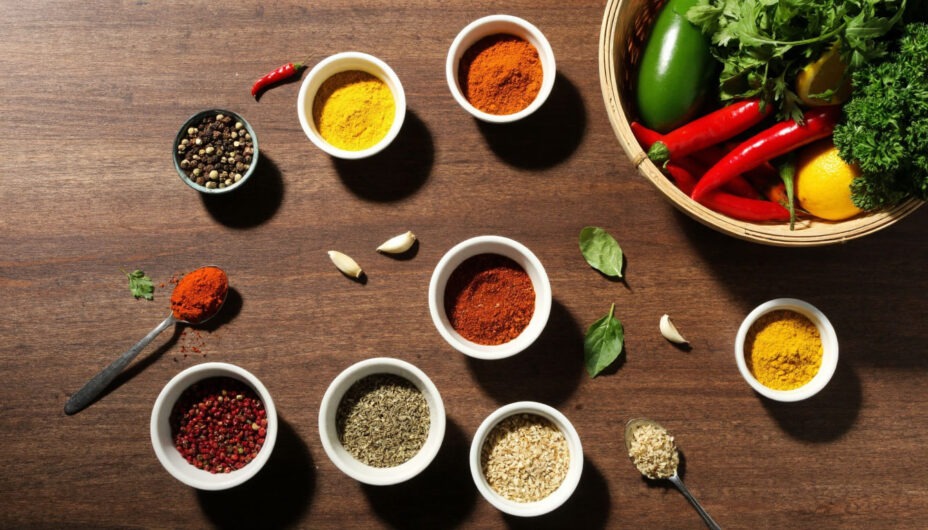 Сочетание специй с овощами кухонный стол со специями и корзиной свежих овощей